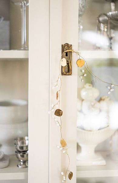 Girlang i mässing med vita bär