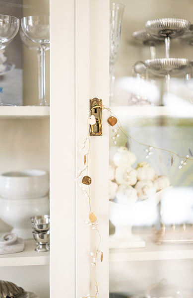 Girlang i mässing med vita bär