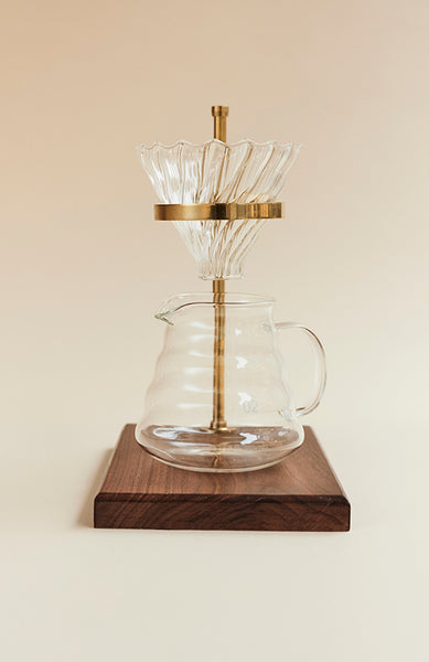 Slow coffee ställning i valnöt och mässing med kanna och filterhållare i glas.